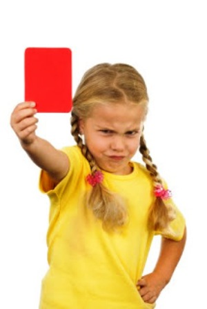 ein kleines mädchen zeigt die rote karte